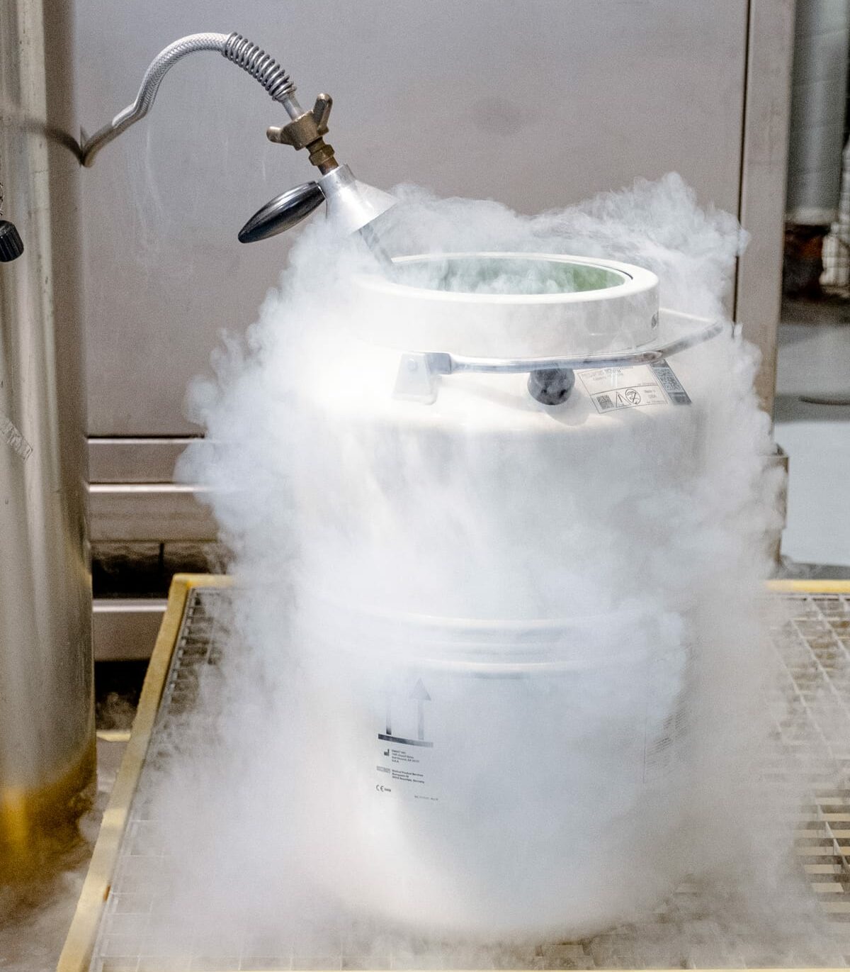 Vapour rising from a liquid nitrogen vessel during controlled transfer, illustrating cryogenic storage conditions.