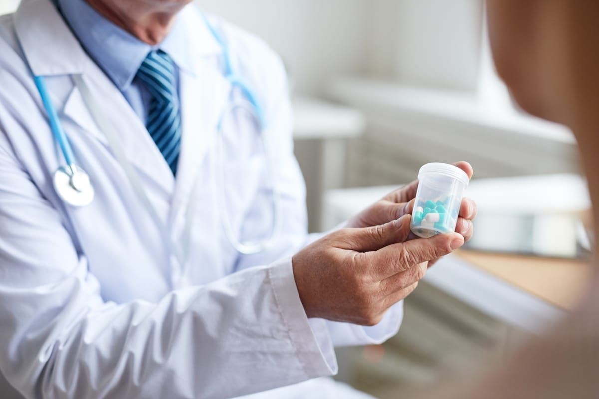 Clinical Drugs Logistics: Man Holding Pills Bottle