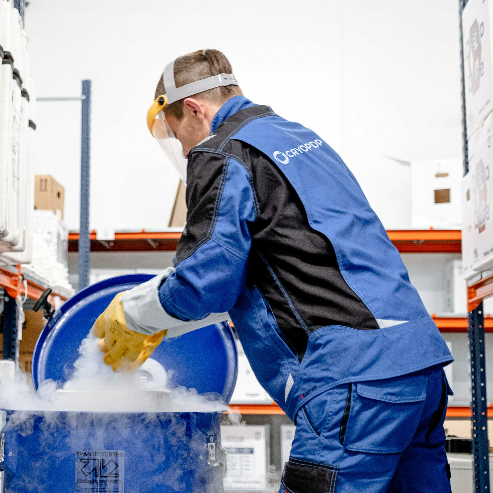 CRYOPDP technician handling a cryogenic container inside a temperature-controlled storage facility.