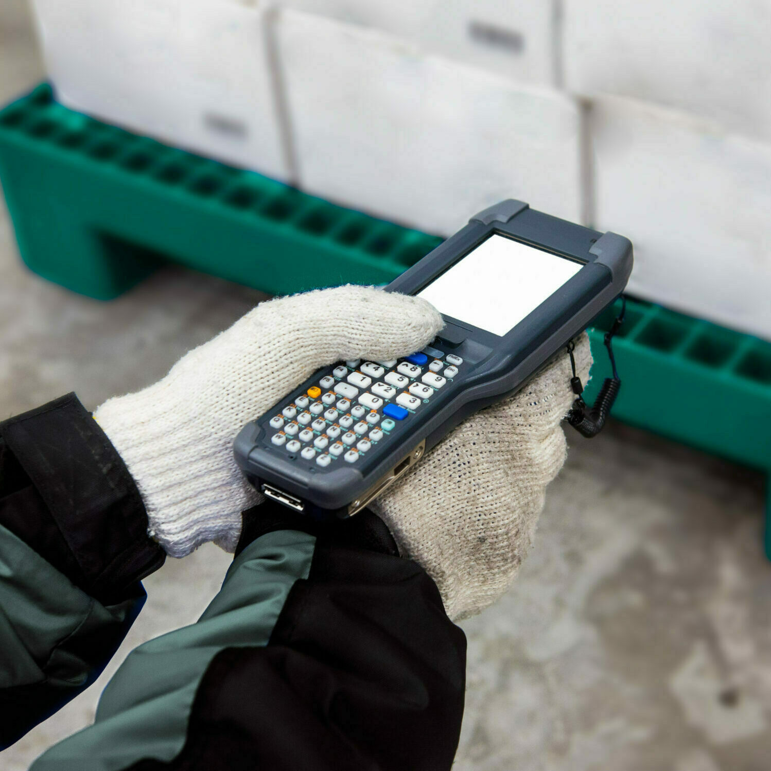 Gloved worker using a handheld scanner in a logistics environment