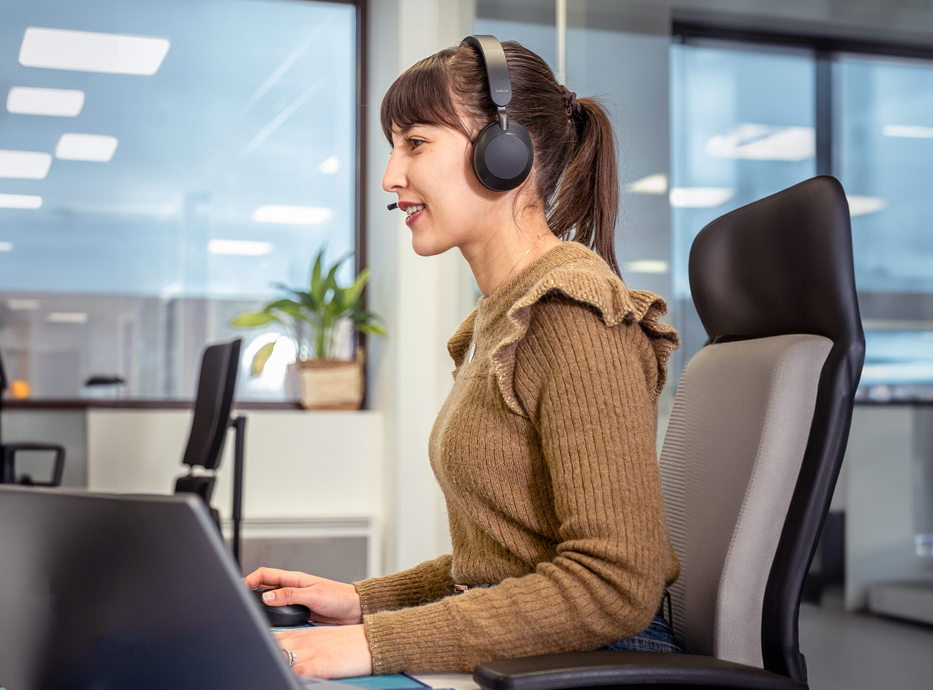 Customer support representative wearing a headset, assisting with Onboard Courier logistics at CRYOPDP.