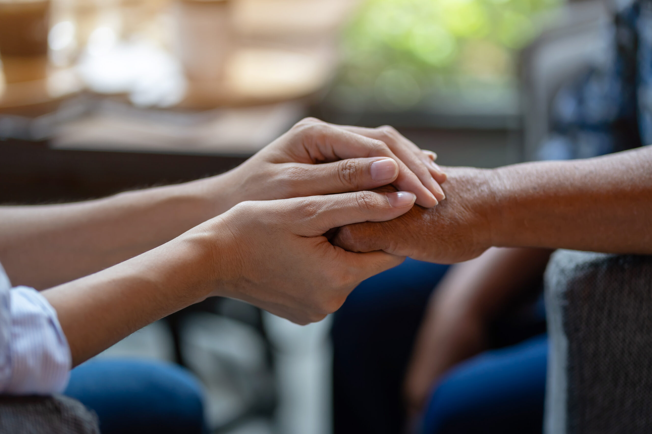 Close-up of two people holding hands, symbolising the human care behind white gloves logistics in healthcare delivery.
