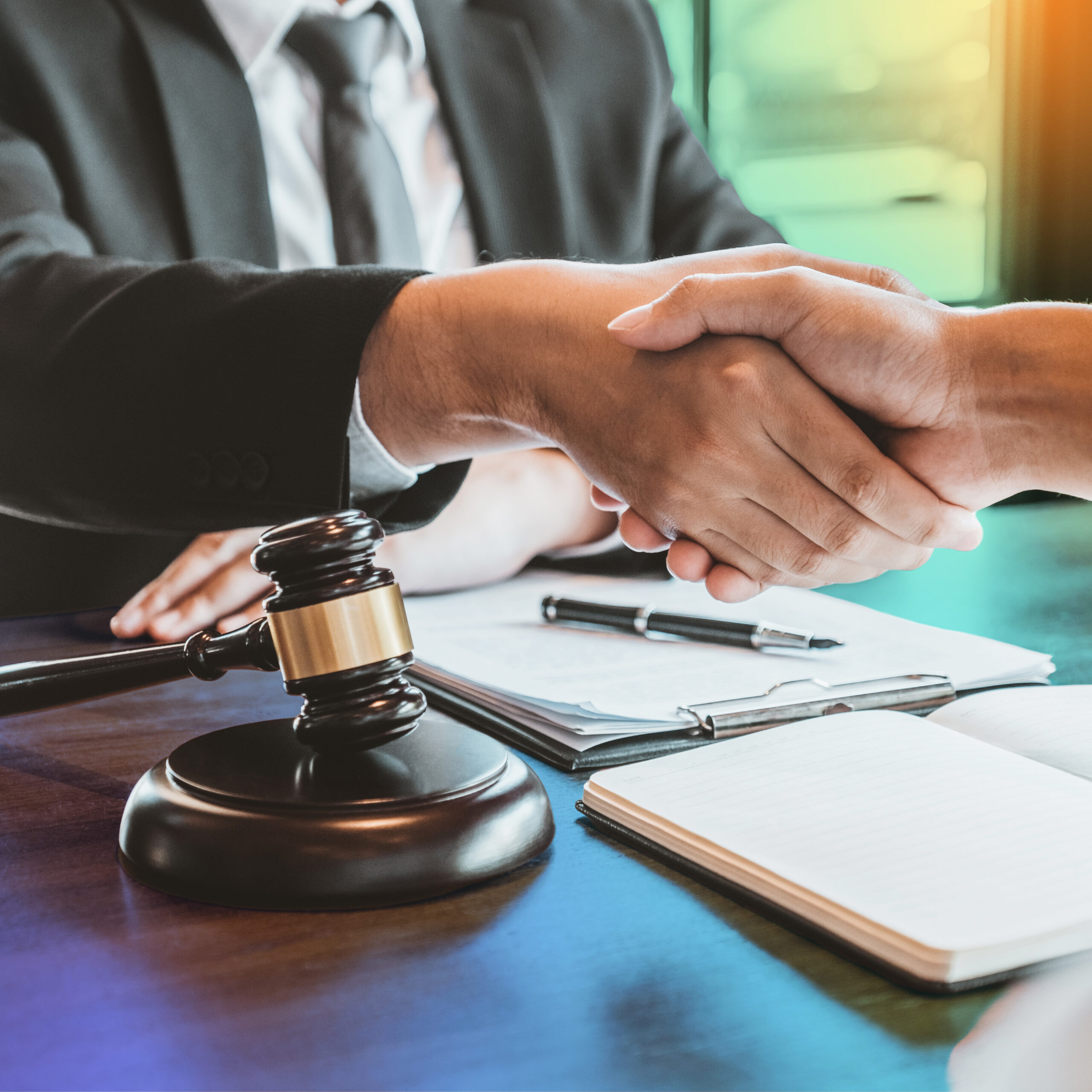 Business handshake in legal setting symbolising compliance and regulatory partnerships