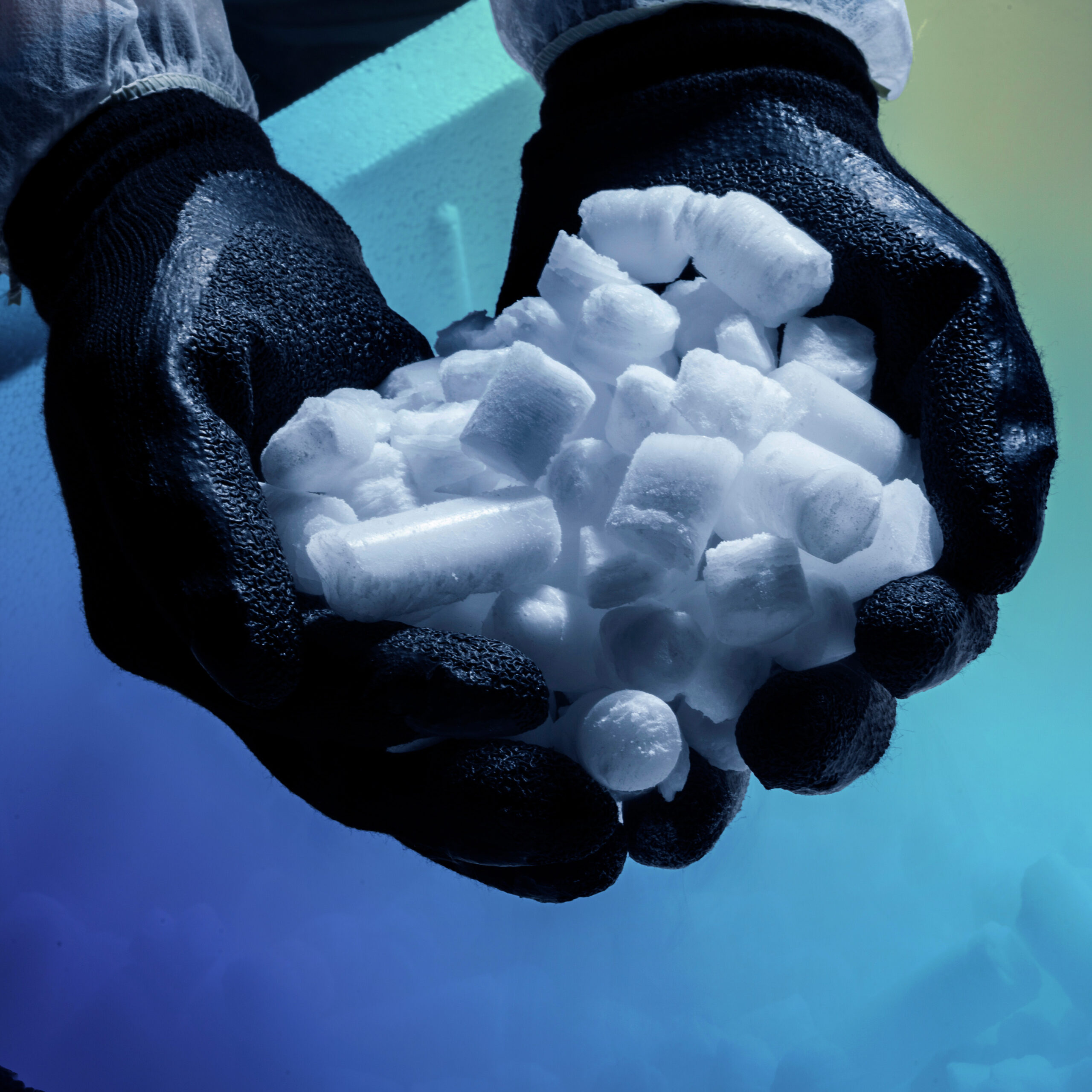 Gloved hands holding dry ice for temperature-controlled logistics
