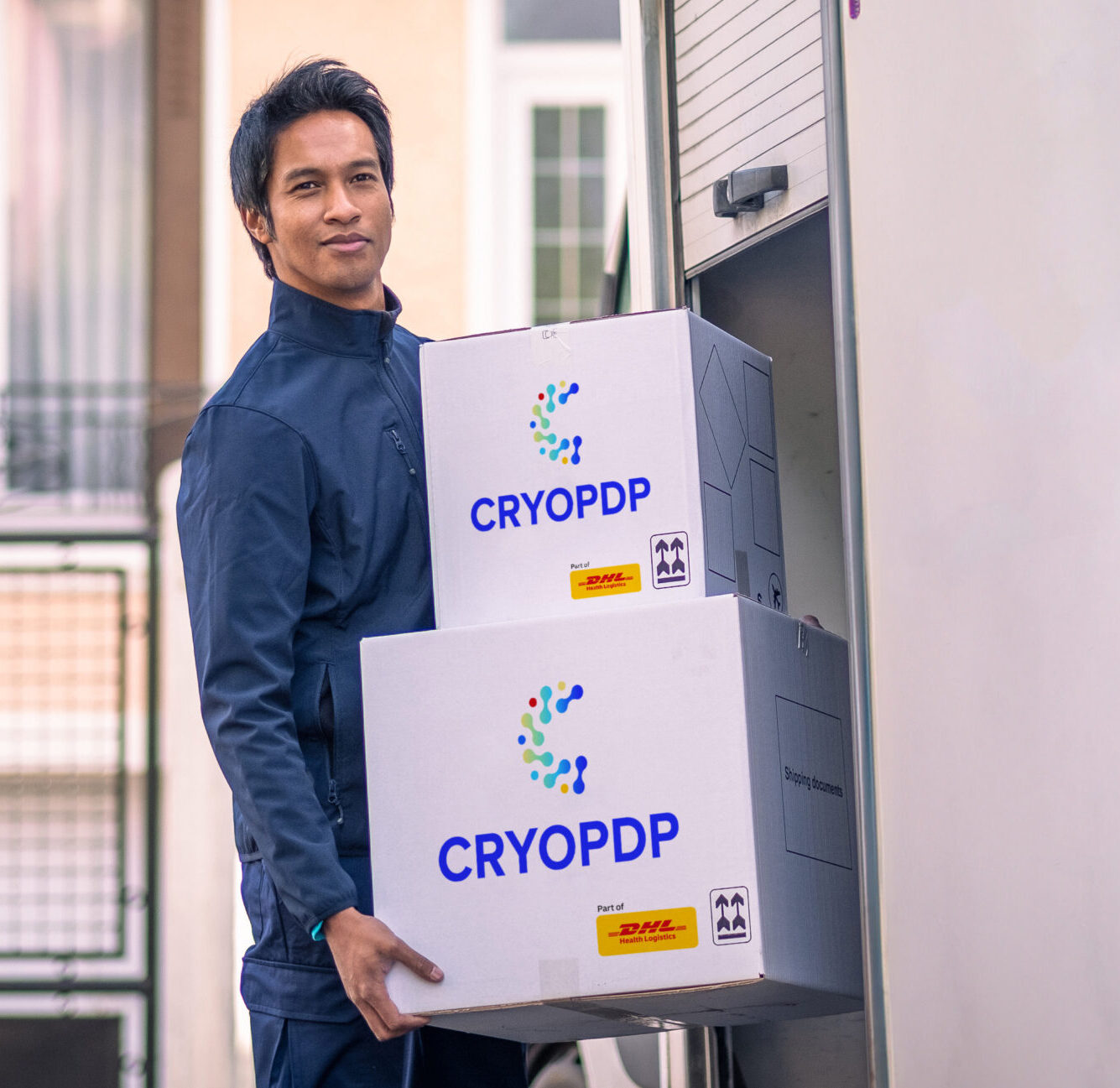 CRYOPDP driver loading temperature-controlled boxes into a vehicle, representing white gloves handling in time-critical healthcare logistics.