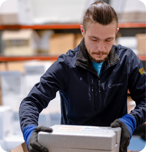 Clinical trial logistics specialist preparing a temperature-controlled shipment inside a logistics facility.